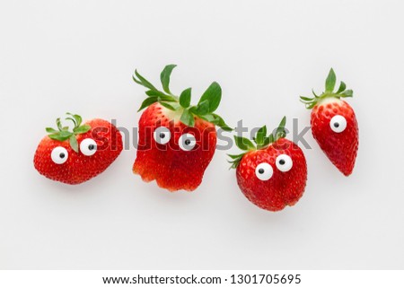 Funny faces strawberries on a white background, creative healthy food concept, top view