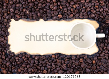 Coffee mug on a sheet of old paper on the background of coffee beans.