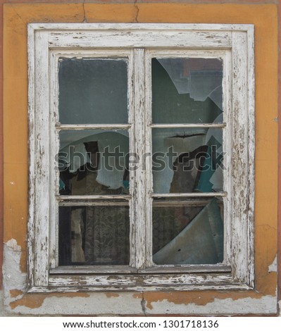 Old ruin wooden window with broken glass on old house