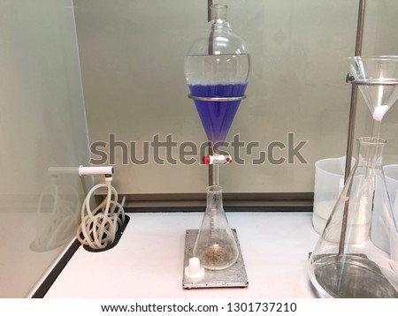 separating natural product use dichloromethane with water have two layer blue and white in separating funnel Royalty-Free Stock Photo #1301737210