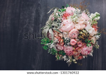 Big beautiful wedding bouquet of spring  flowers on wooden background. Peonies, roses, tulips, grass. Wedding concept.