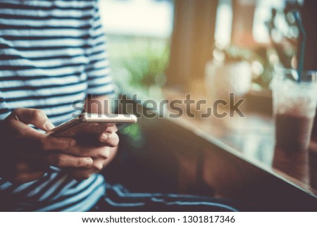 Woman hand using smartphone with cafe shop colorful beautiful bokeh background. Business, financial, trade stock maket and social network concept.