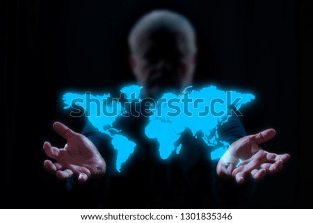 a man holds a digital map of the world in front of black background