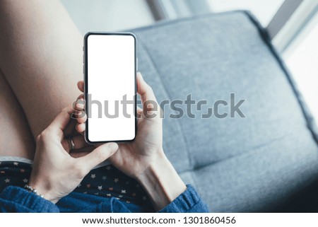 Mockup image man hand holding texting using black mobile,cell phone at desk with copy space,white blank screen for text.concept for contact business,people communication,technology electronic device. 
