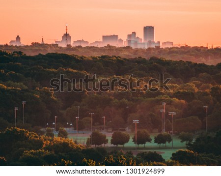 Milwaukee's skyline pictured from atop a hill during sunrise. 