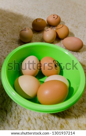 Lots of fresh chicken eggs with smiling faces in the green basket from the top view. Show your emotions. Organic food ingridients close up. Stay healthy concept.