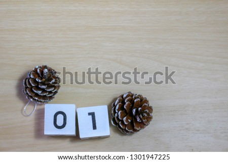 Number one and pine cone on wooden table with copy space