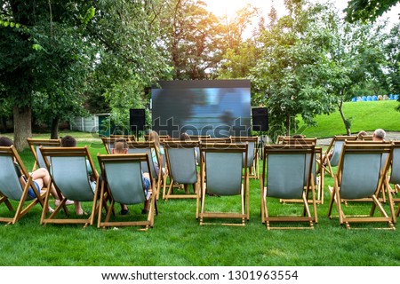 People in a summer cinema are watching a movie.