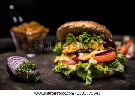 A picture of a homemade burger with fries, oignons, tomatoes and mushrooms. Authentic food for hungry people.
