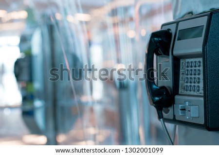 Public payphone in an airport building and blur background Royalty-Free Stock Photo #1302001099