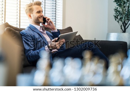 caucasian businessman working hand hold tablet working with positive motivation  smiling with happiness in lobby office background