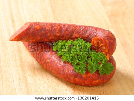 hungarian sausage with parsley on wooden background