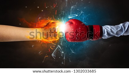 Two hands fighting and breaking glass into small pieces with fire and water concept