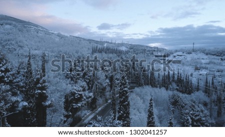 Top view of the city near the sea in winter. Shot. Snowy expanses in the mountainous area near the city