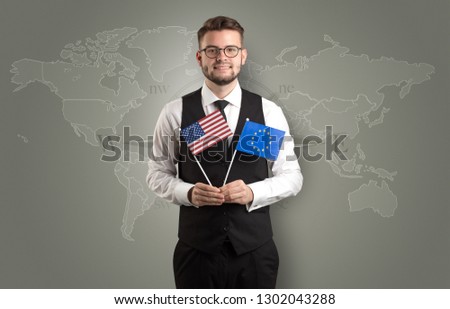 Cheerful businessman standing in front of a map with flag on his hand