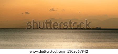 Panoramic view of ship at sunset with mountains
