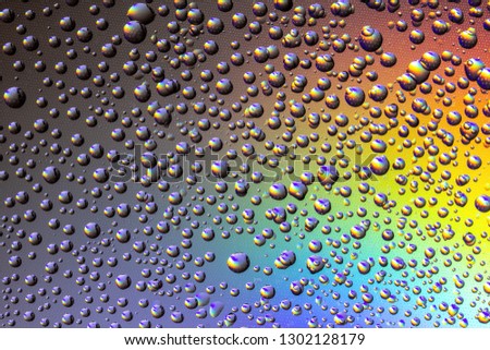 Drops of water on the glass, with the reflection of the rainbow.