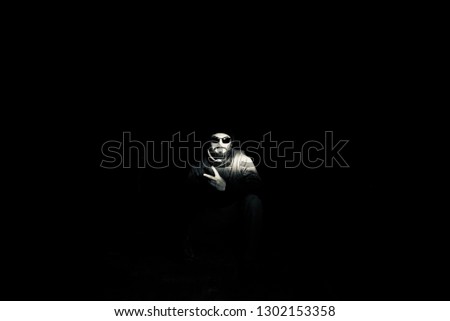Young man wearing sunglass sitting in a place at night