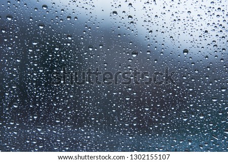 Rain droplets on window with out of focus background 