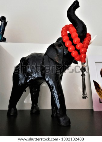 decorative wooden elephant and red rosary