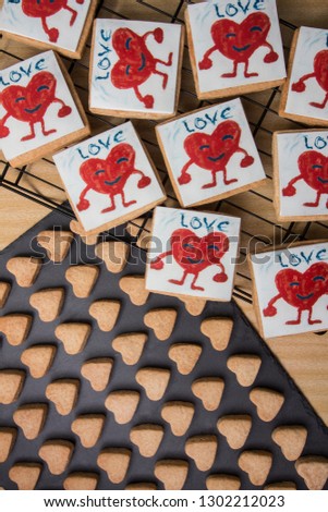 square cookies for Valentine with children's drawing of a red heart. Romantic snack. February 14th. In love Sugar paste, fondant. Illustration. Creativity. Handmade. Crafts.