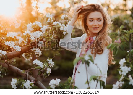 gorgeous blonde girl in blossoming garden. Girl near tree not look into camera. Girl in spring  garden. Spring concept. Beautiful girl in orchard