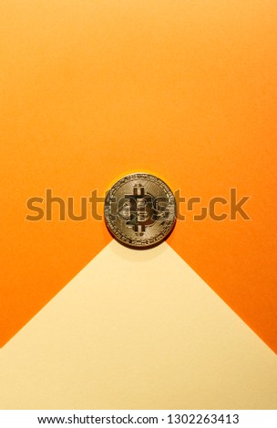 Bitcoin coin on coloured geometric shapes. Pastel tones. Copy space. Cryptocurrencies concept with coin on geometric paper sheets.