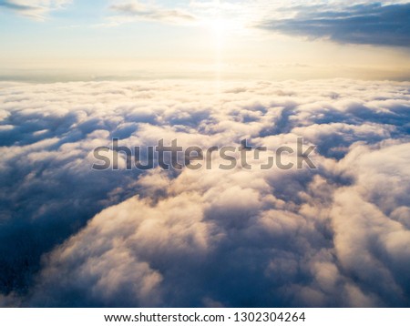 Aerial view White clouds in blue sky. Top view. Drone. Aerial bird's eye fly. Aerial top view cloudscape. Texture of clouds. View from above. Sunrise or sunset over clouds. Panoramic 