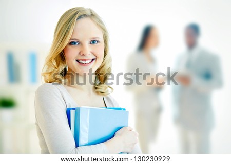 Portrait of happy businesswoman with documents looking at camera