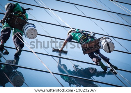 group of workers cleaning windows service on high rise building Royalty-Free Stock Photo #130232369
