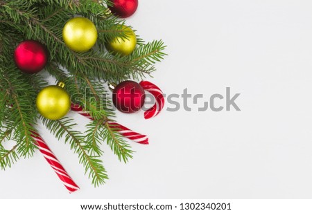 Merry Christmas and Happy New Year composition with colorful balls, candy lollipops and fir-tree  on white background.