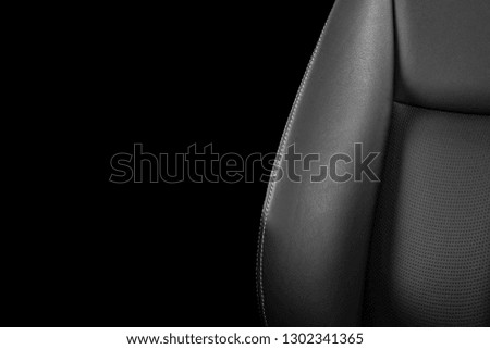 Black leather interior of the luxury modern car. Perforated Leather comfortable seats with stitching isolated on black background. Modern car interior details. Car detailing. Car inside