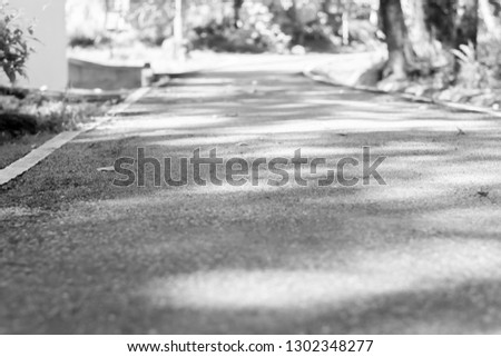 Concrete road heading straight ahead and natural background.Black and white tone.
