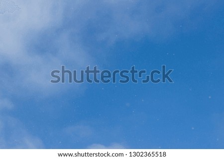 Blue sky. Blue sky with light clouds. From the blue sky it is snowing. Winter bright blue sky
