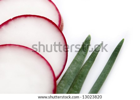 radish slices and green chives on white background