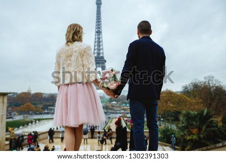 A couple is holding hands at the Eiffel Tower. The romantic city. Paris, France.