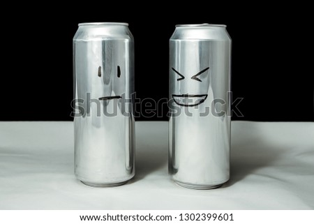 Concept of friends. Joke over a friend but it's not funny. Aluminium cans with drowing emoticons, Emoji of laugh and poker face