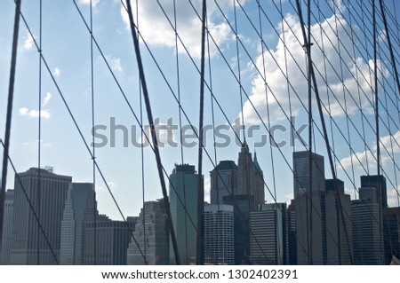 A view of a cluster of office buildings and skyscrapers situated in New York City's Lower Manhattan as viewed from the Brooklyn Bridge.