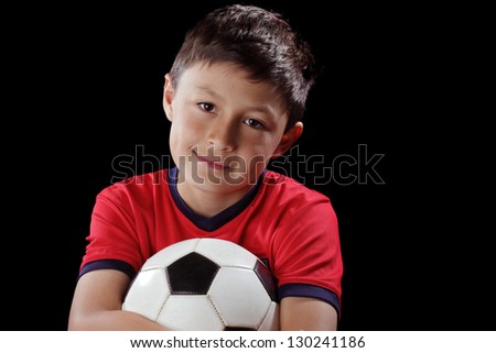 Boy with soccer ball on black background with dramatic lighting style