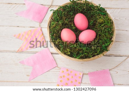 Easter. Easter eggs lie in a basket, a nest with moss on a white wooden background. Spring, April. selective focus.