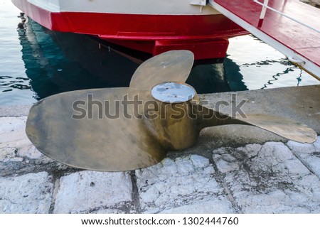 Ship propeller lying on the coast. Ship propeller with three blades.
