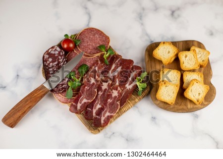 Meat, sausage and toasts on a marble background, the top view