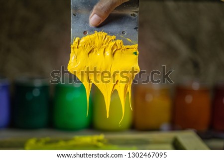 yellow color dripping from hand screen printing during printing tee shirt in tee shirt factory.