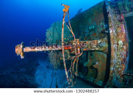 A large, underwater shipwreck in a tropical blue ocean
