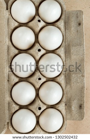 Cardboard egg rack with eggs on rustic background with copy space for text