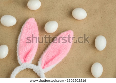 Top view of bunny ears easter holiday accessory and white egg on rustic background with copy space