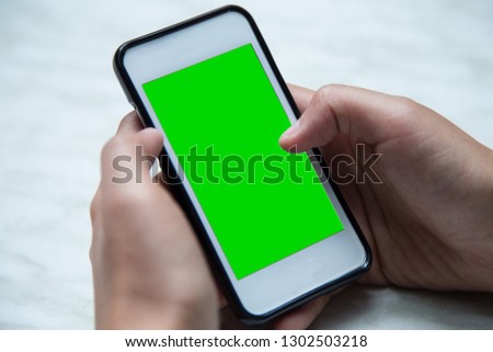 Person hand using mobile smartphone with green screen - Image