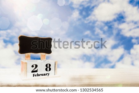 Calendar box with blackboard for entering text,February 28 days Place on wooden table,bright blue sky background, copy space and in put text,decorate website or wallpaper