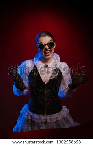 Emotional woman in steampunk costume posing in blue and red stage light