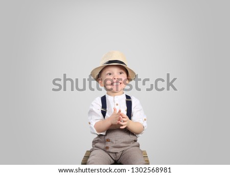 Cute little boy in a hat and trousers with suspenders